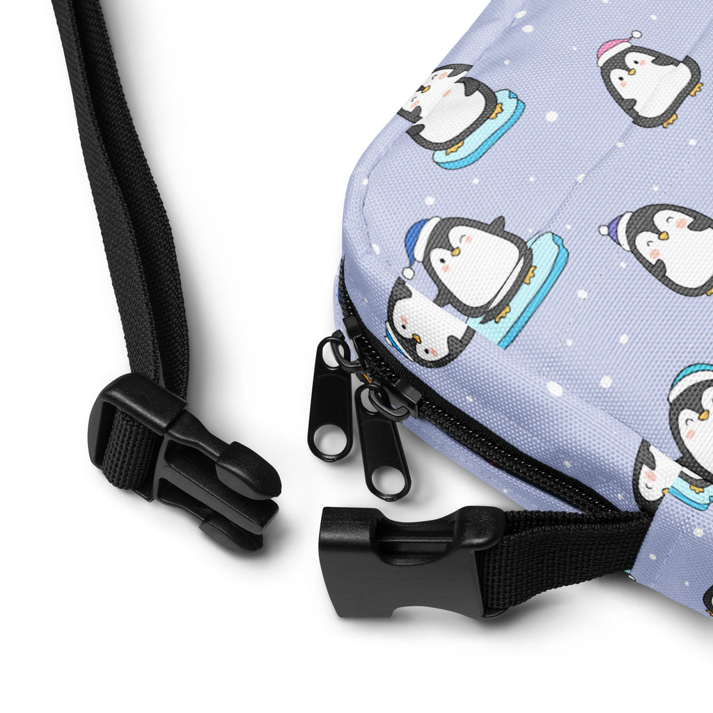 Light purple penguin-themed women’s crossbody purse with black zippers and adjustable straps for winter use