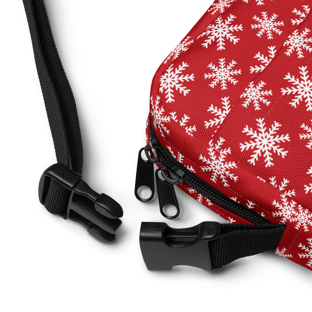 Red snowflake Christmas women’s crossbody purse with red fabric, white snowflake pattern, and black zipper pulls