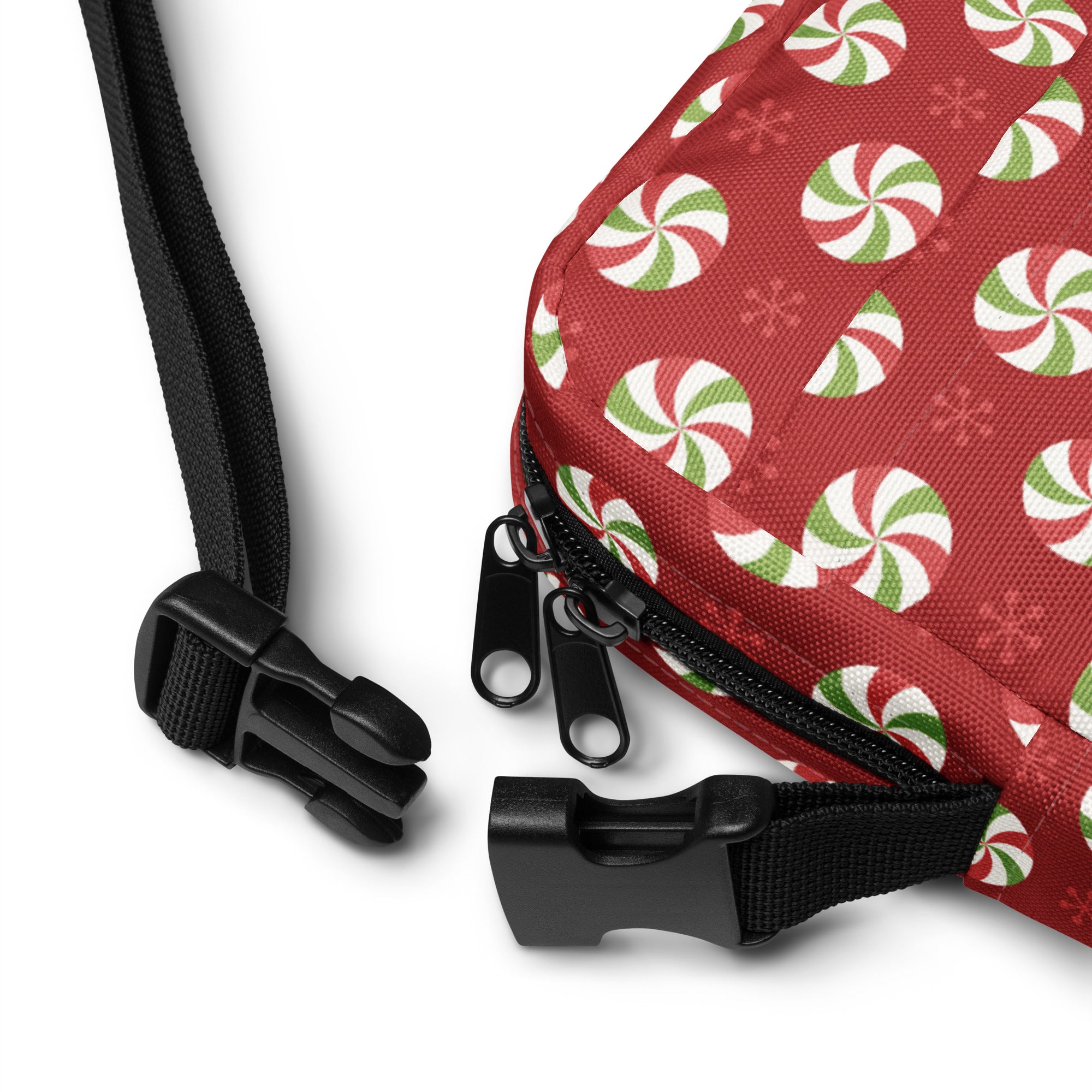 Girls peppermint candy crossbody purse in red fabric with festive peppermint swirl pattern and black zipper pulls