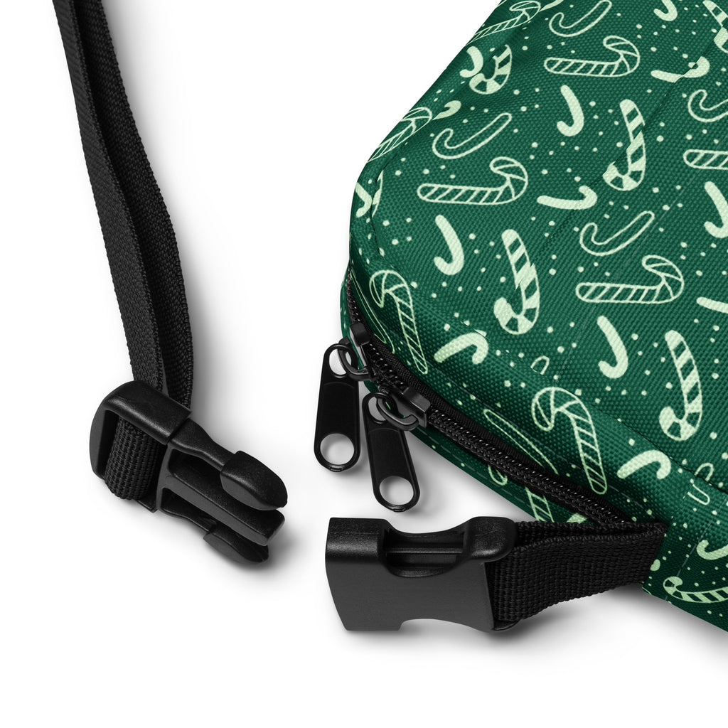 Green candy cane patterned drawstring crossbody purse with black zipper pulls and adjustable straps for women