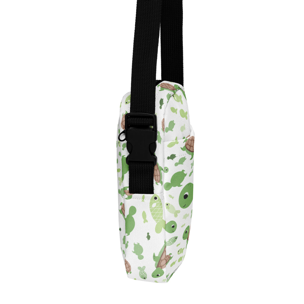Girls green sea turtle crossbody purse in white with playful green and brown cartoon turtles and black adjustable straps