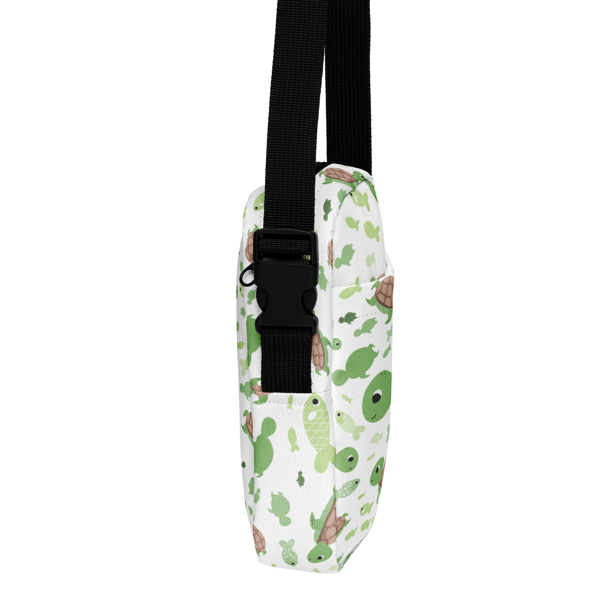 Girls green sea turtle crossbody purse in white with playful green and brown cartoon turtles and black adjustable straps