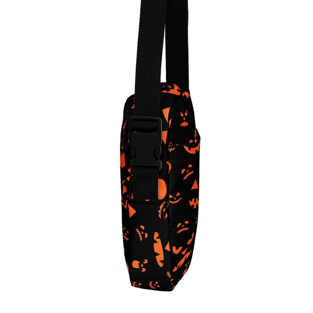 Black fabric crossbody bag with orange jack-o-lantern faces and an adjustable strap for girls halloween use