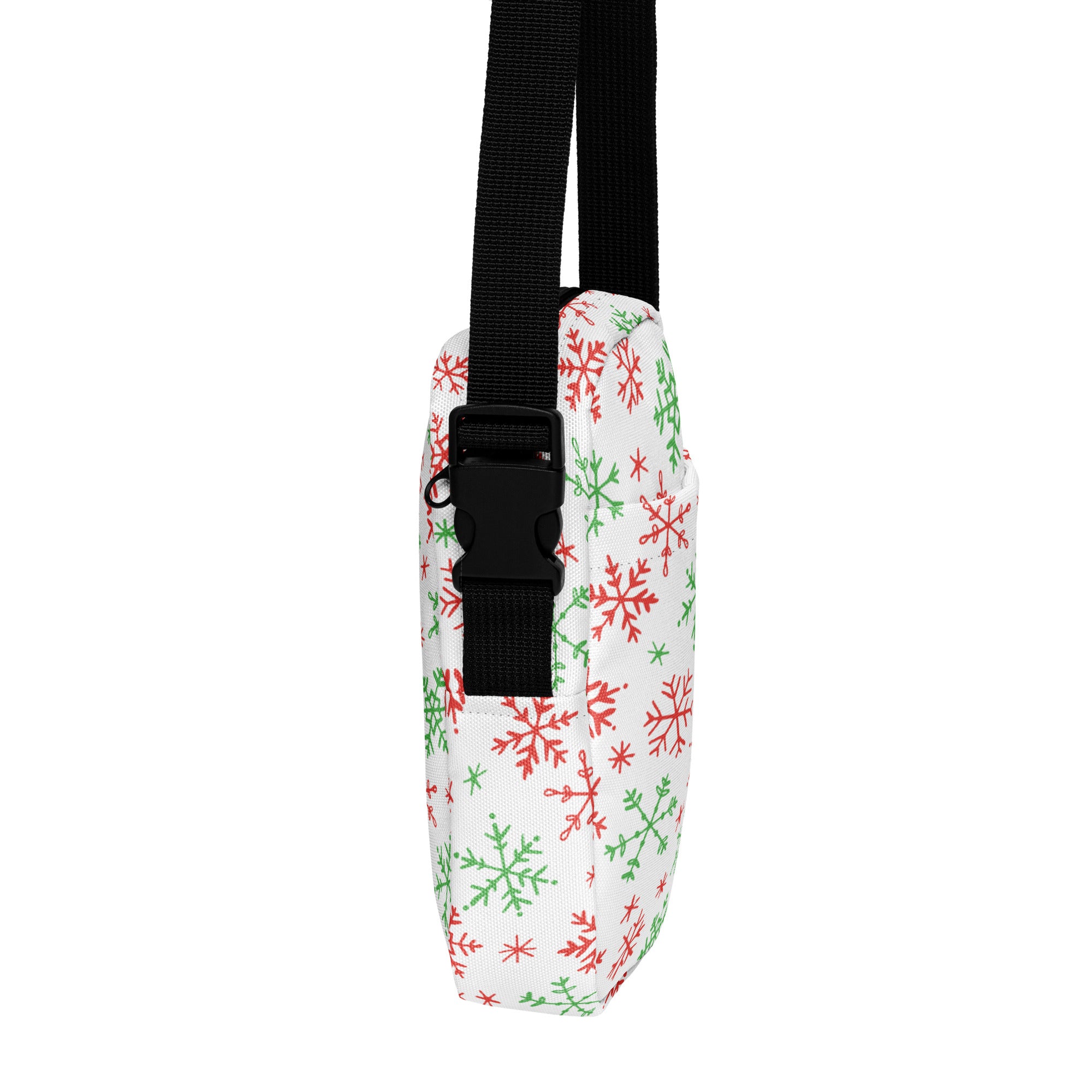 White fabric crossbody bag with red and green snowflake pattern and black adjustable strap for Christmas use