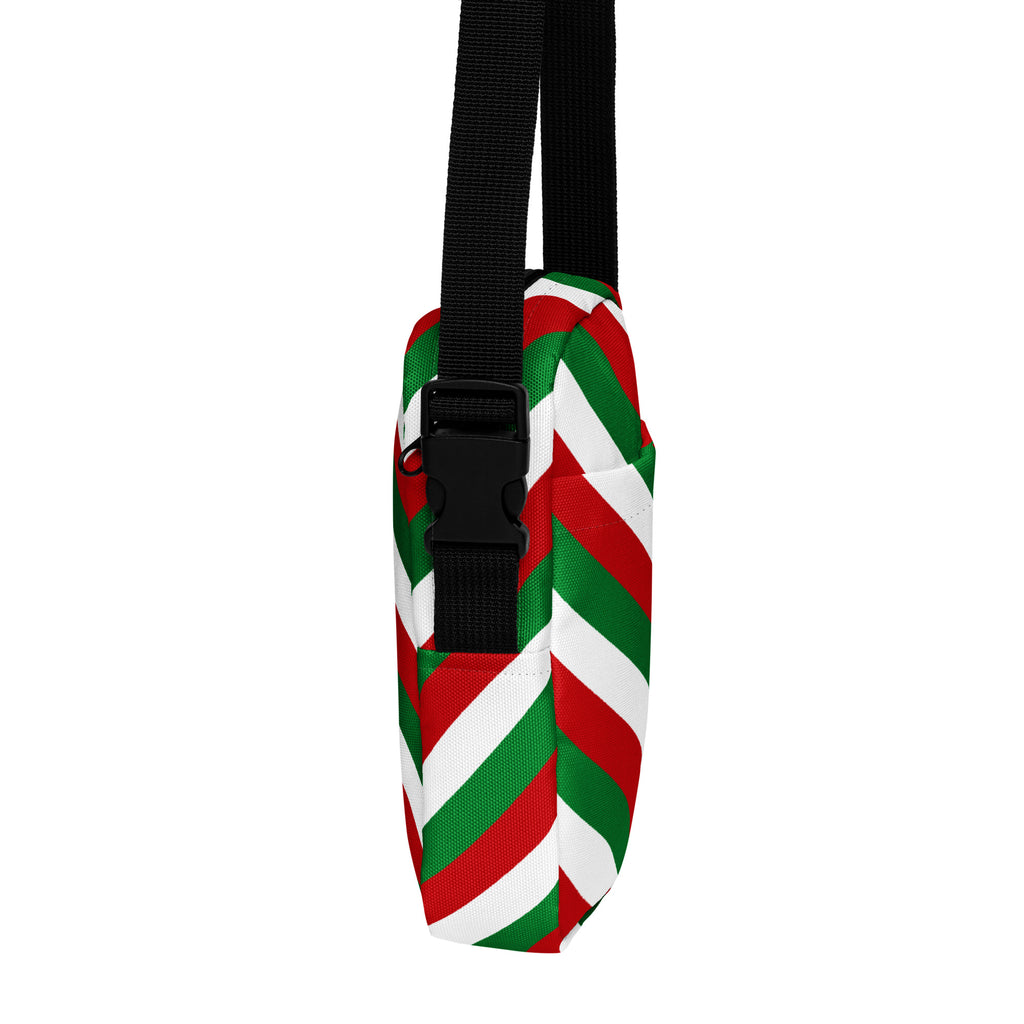 A festive red green and white diagonally striped canvas crossbody bag with a black adjustable strap for women