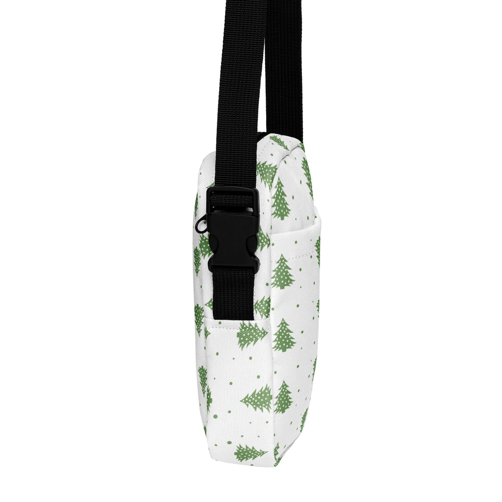 White crossbody bag with green pine tree pattern and black adjustable strap for winter and Christmas use