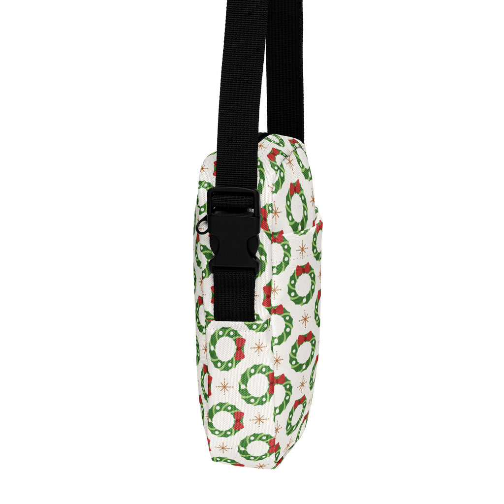 Girls Christmas wreath crossbody purse in white fabric with green wreaths red bows and black adjustable strap and buckle