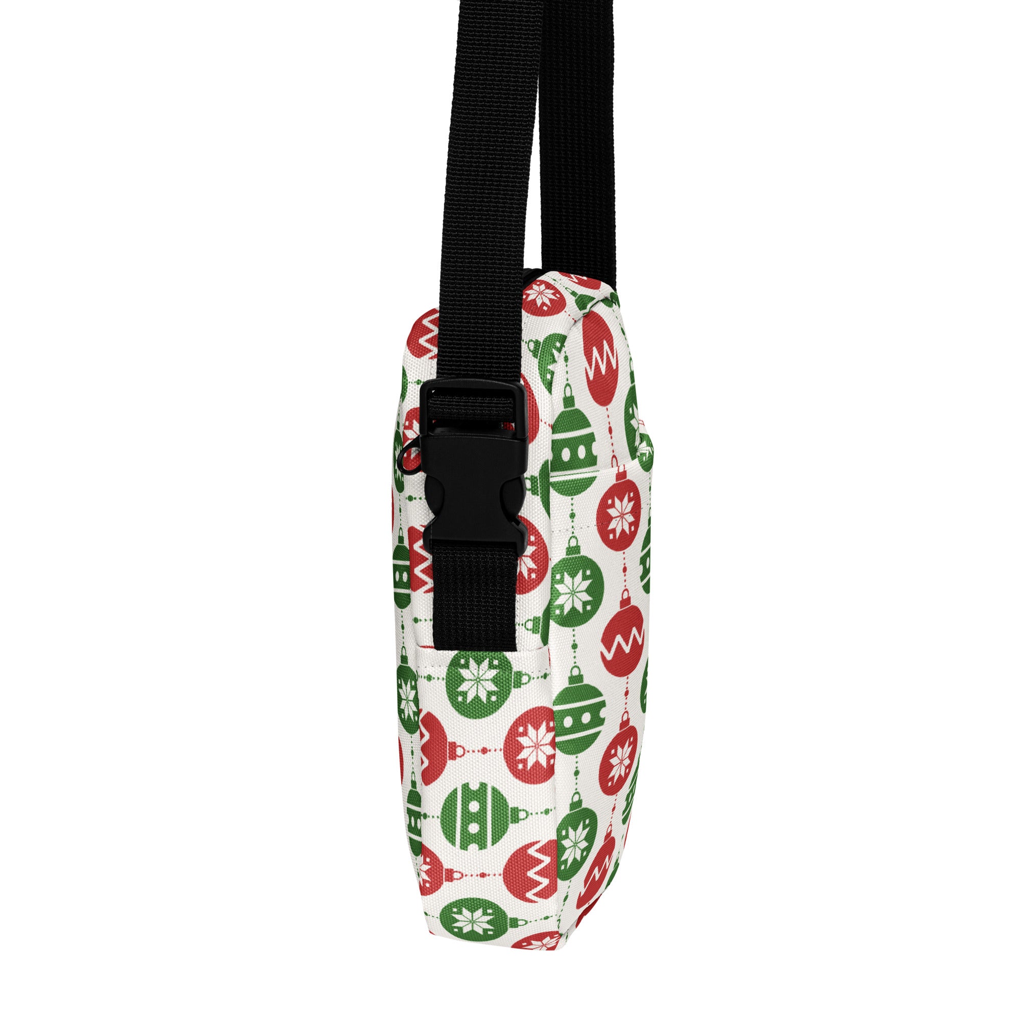A festive white girls crossbody purse with red and green Christmas ornament patterns and a black adjustable strap