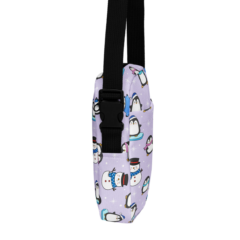 Girls winter penguin crossbody purse in lavender fabric with cartoon penguin and snowman pattern and black adjustable strap