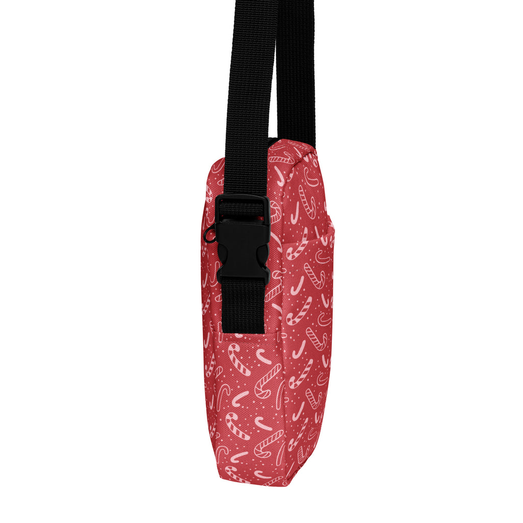 Girls red candy cane crossbody purse with black strap and buckle featuring a festive candy cane pattern
