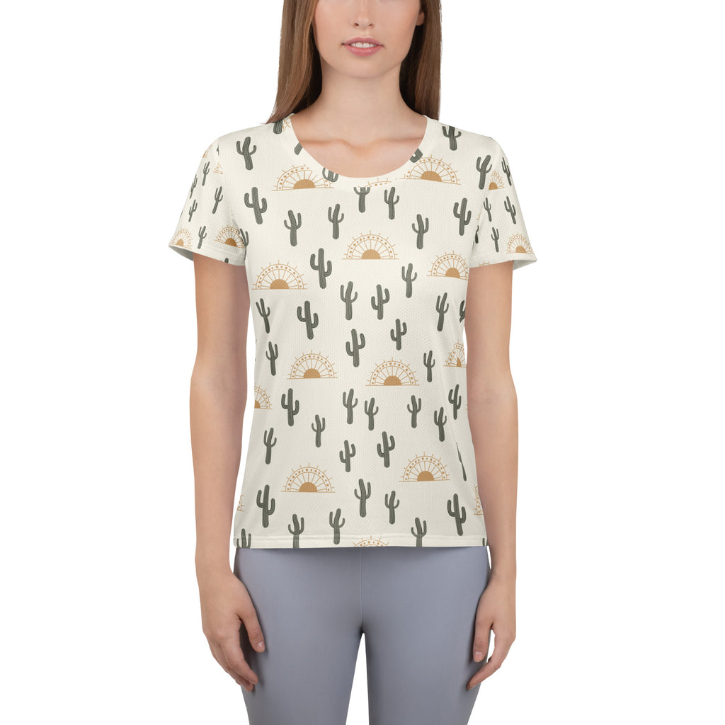 Cream-colored women’s performance athletic t-shirt with black cactus and gold sunburst pattern, lightweight and moisture wicking