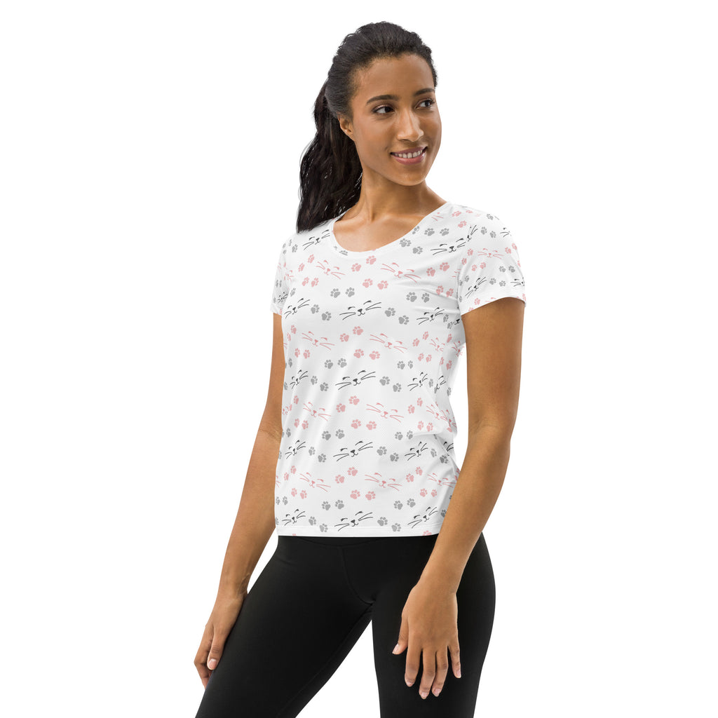 White women’s short-sleeved cat paw print performance t-shirt with black pink gray cartoon cats and moisture wicking fabric