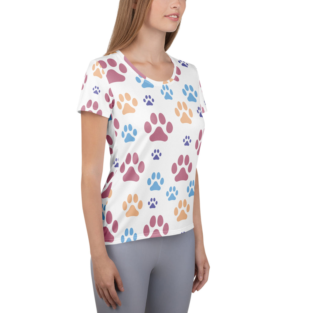 White women’s short-sleeved performance t-shirt with multicolored paw print pattern, lightweight moisture wicking fabric and UPF 50+
