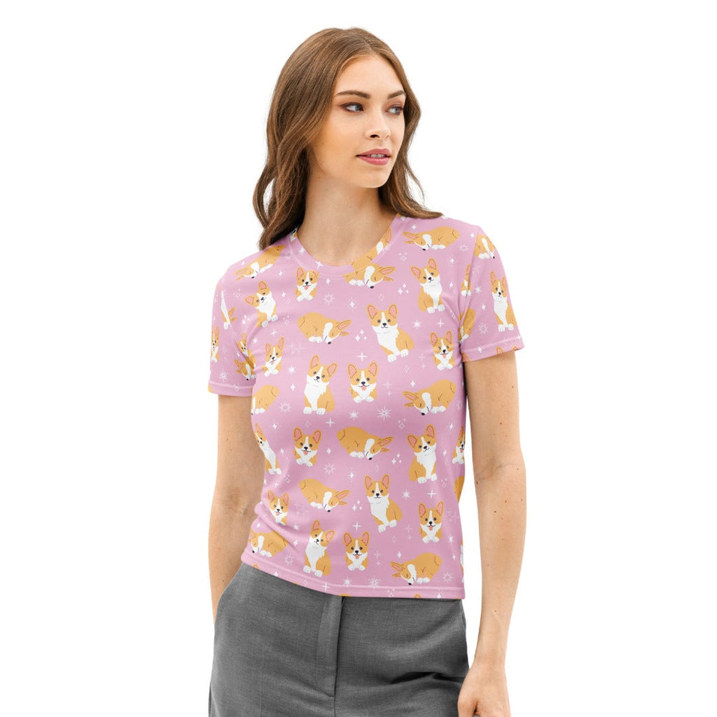 Women’s pink cotton t-shirt with short sleeves featuring a playful all-over print of tan and white cartoon corgis
