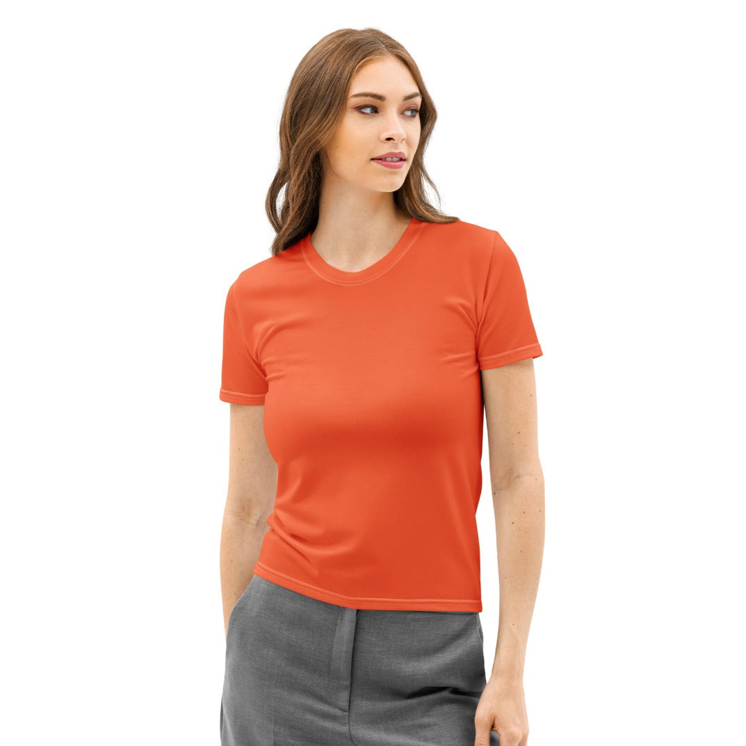 Woman wearing an orange t-shirt and gray pants on a white background