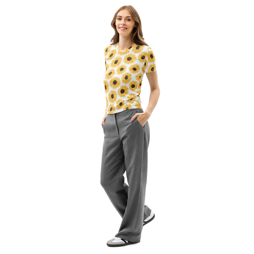 A woman wears a women’s sunflower print cotton t-shirt with soft stretch in yellow on white paired with gray trousers