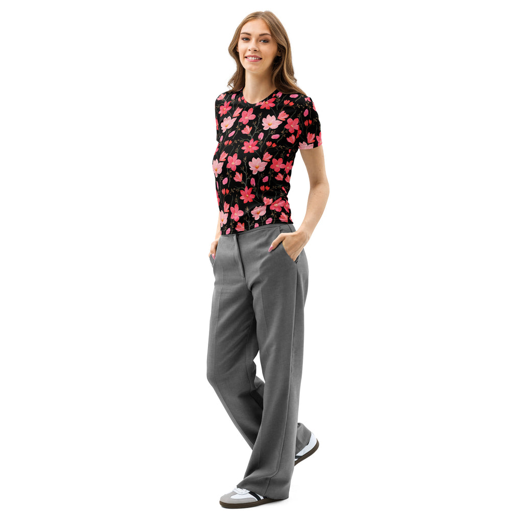 A woman wears a black short-sleeved vibrant pink blossoms cotton t-shirt with soft stretch and pilling resistance