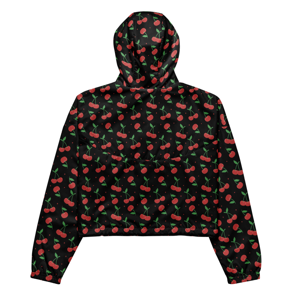 Women’s black cherry cropped windbreaker with vibrant red cherry pattern and adjustable hood shown from front