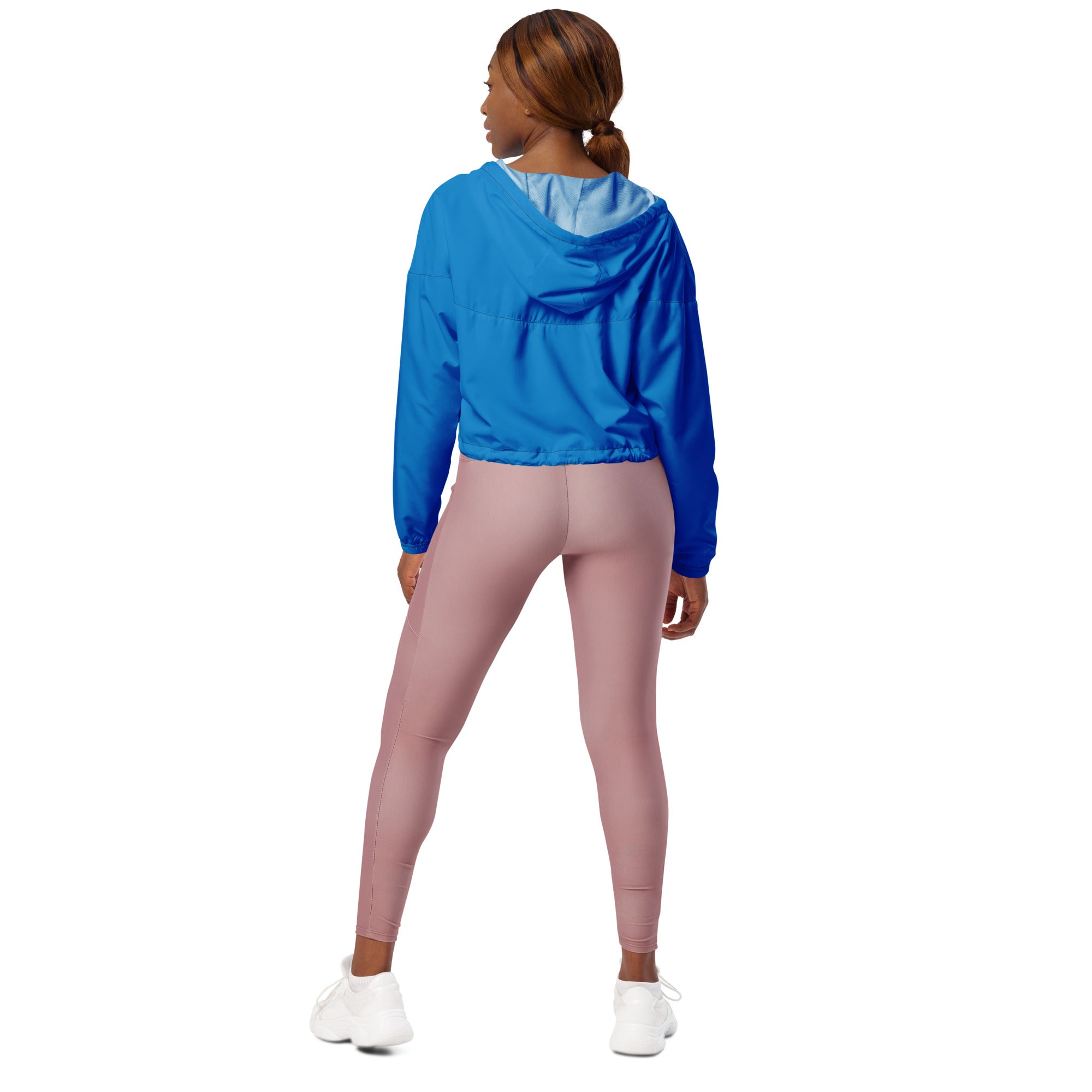 Women’s blue cropped windbreaker with adjustable hood and pockets paired with dusty rose leggings