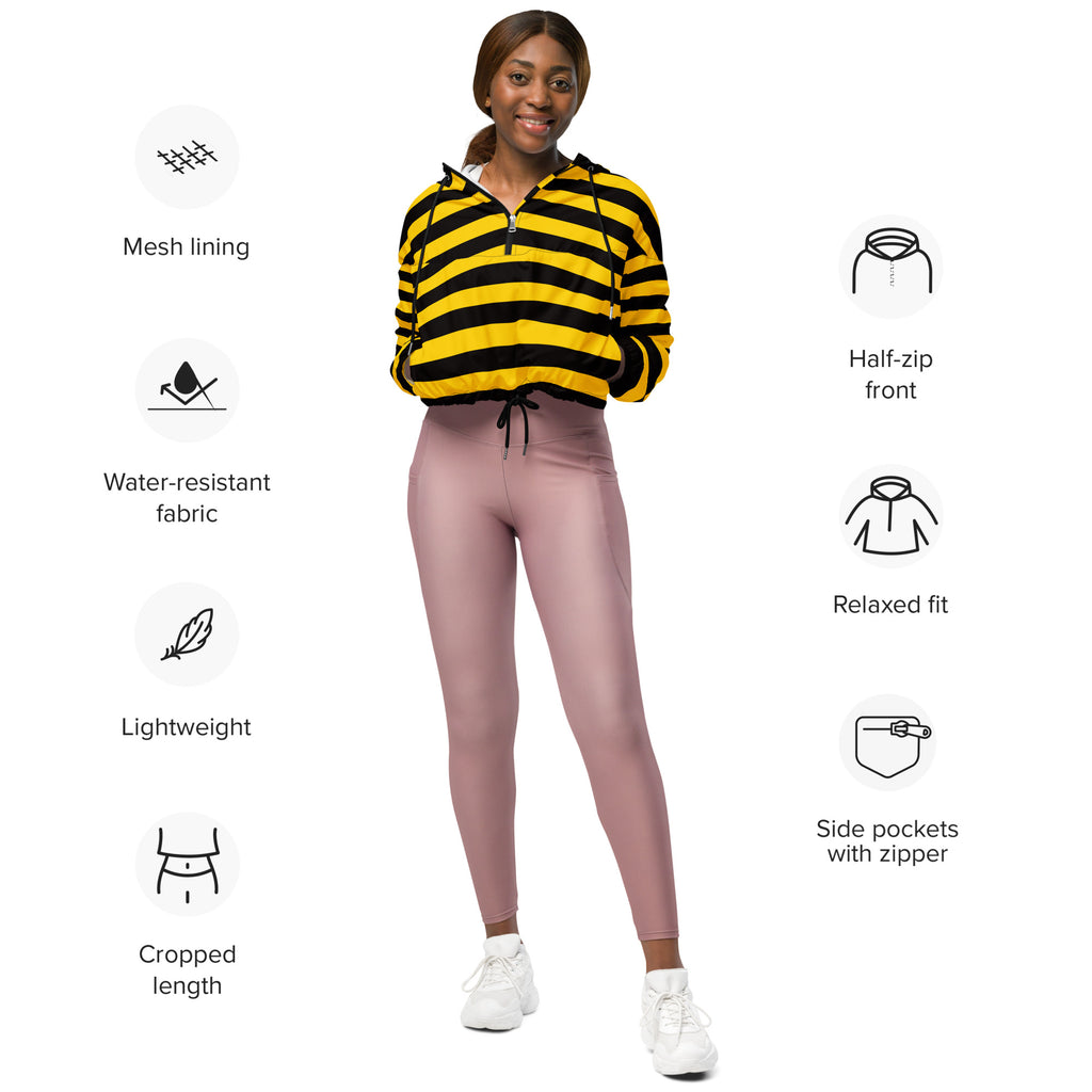 A woman wearing a yellow and black striped cropped windbreaker with mesh lining and zippered pockets