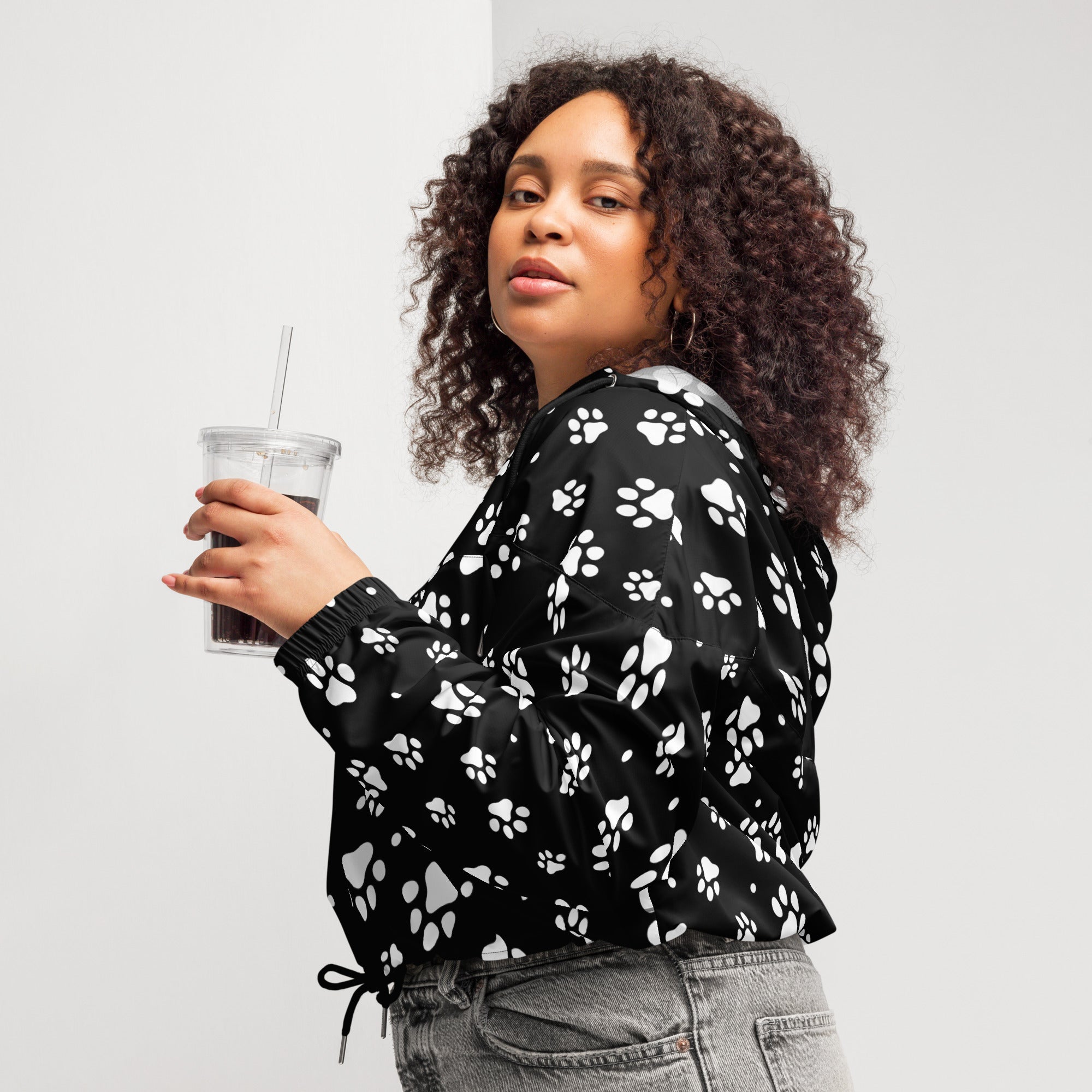 Women’s black lightweight cropped bomber jacket with white paw print pattern featuring adjustable hood and pockets