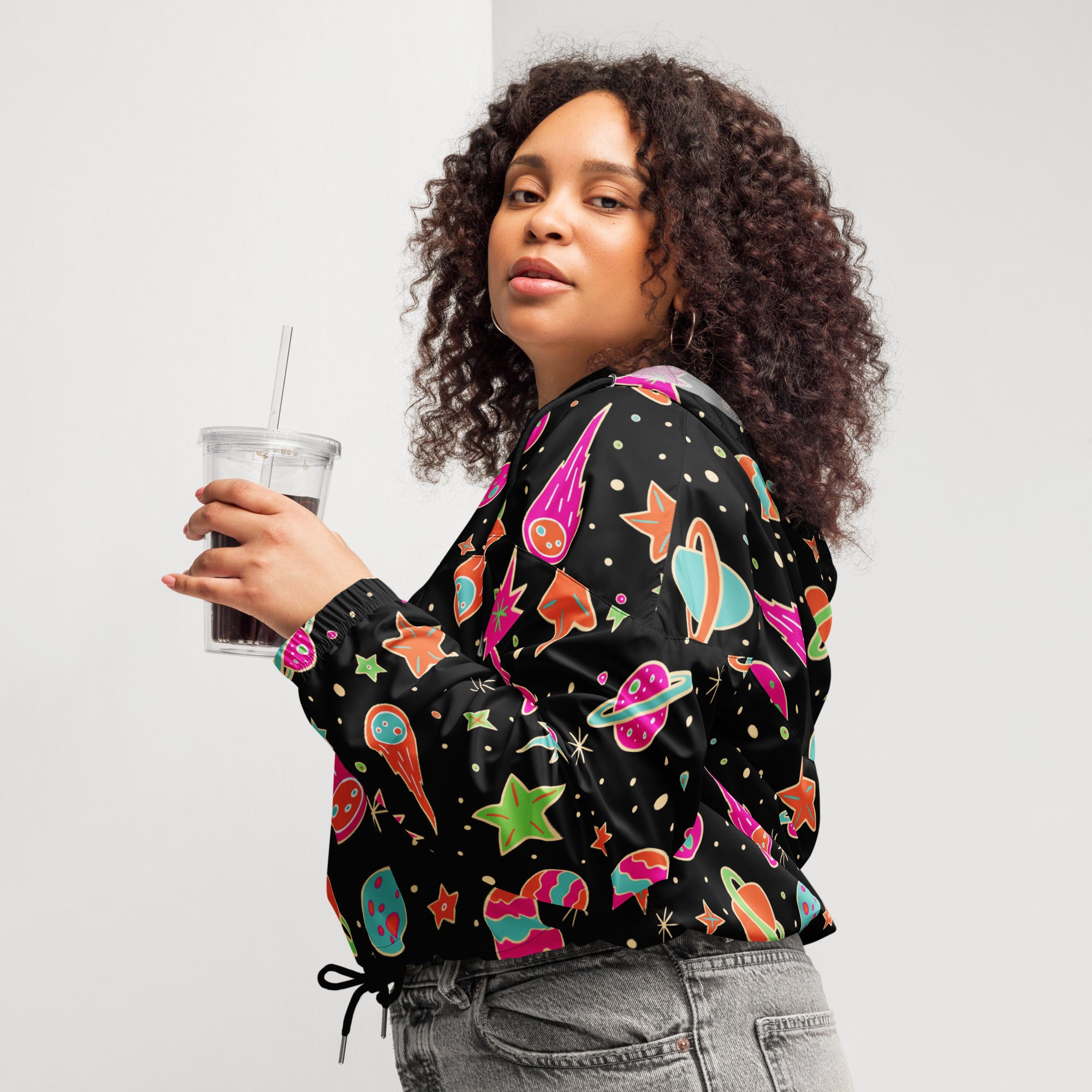 Black women’s retro space cropped windbreaker with vibrant pink teal orange and green space graphics lightweight and water resistant