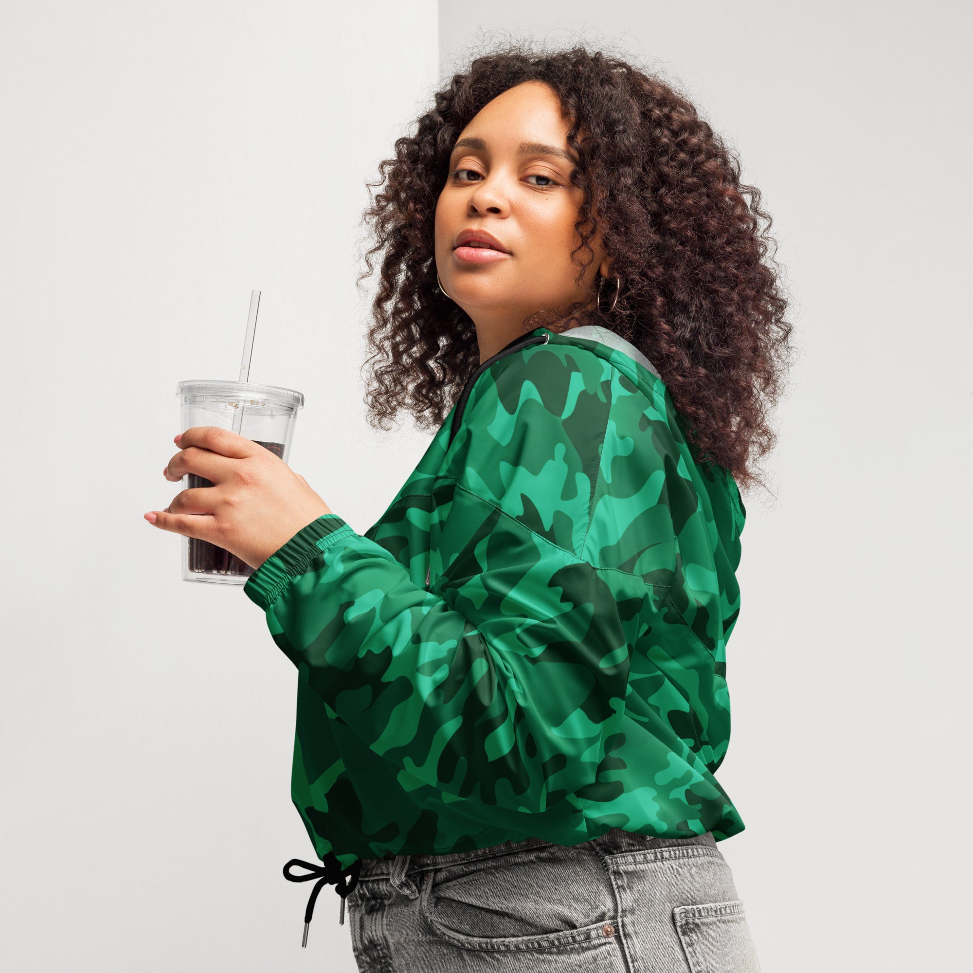 Women’s green camouflage cropped windbreaker with satin-like finish, drawstring waist, adjustable hood, and pockets