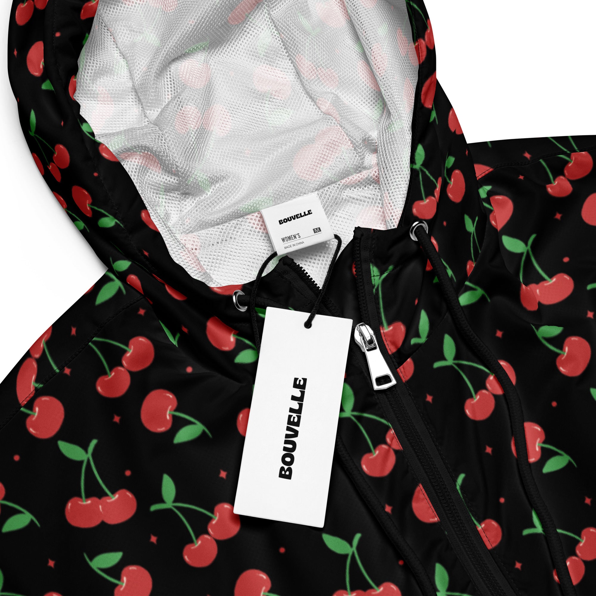 Women’s black cherry cropped windbreaker with red cherry print, adjustable hood with white mesh lining, and pockets