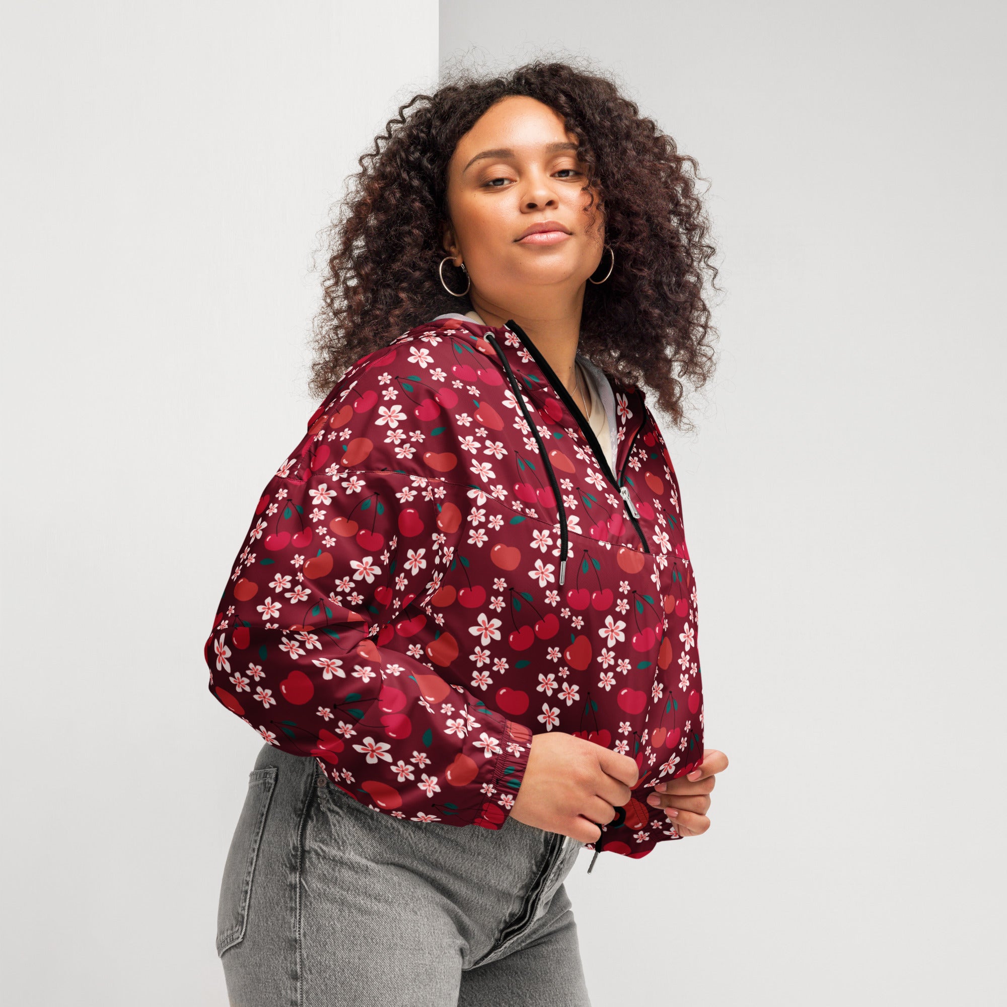 A maroon lightweight women’s cherry blossom cropped windbreaker with cherry and white flower pattern and black zipper accents
