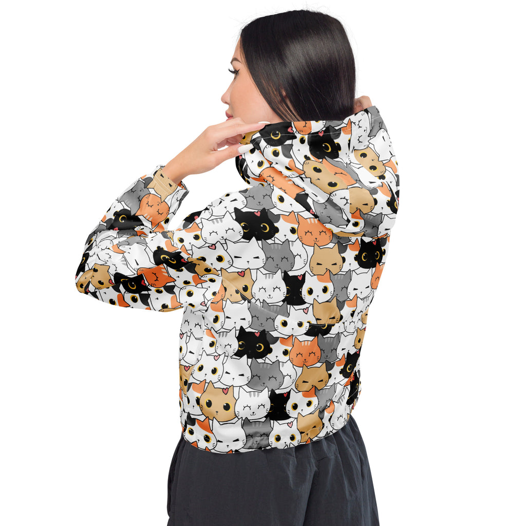 Women’s cropped long-sleeved hoodie with playful black white gray and orange cartoon cats on a white background