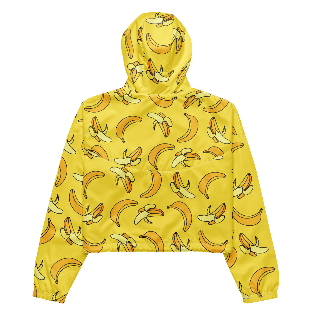 Woman wearing a yellow banana-print cropped windbreaker jacket with adjustable hood and pockets, lightweight and water resistant