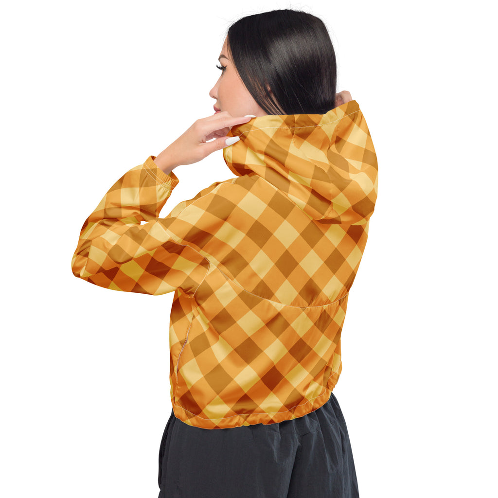 A woman wears a women’s orange gingham cropped windbreaker with a shiny lightweight fabric and adjustable hood