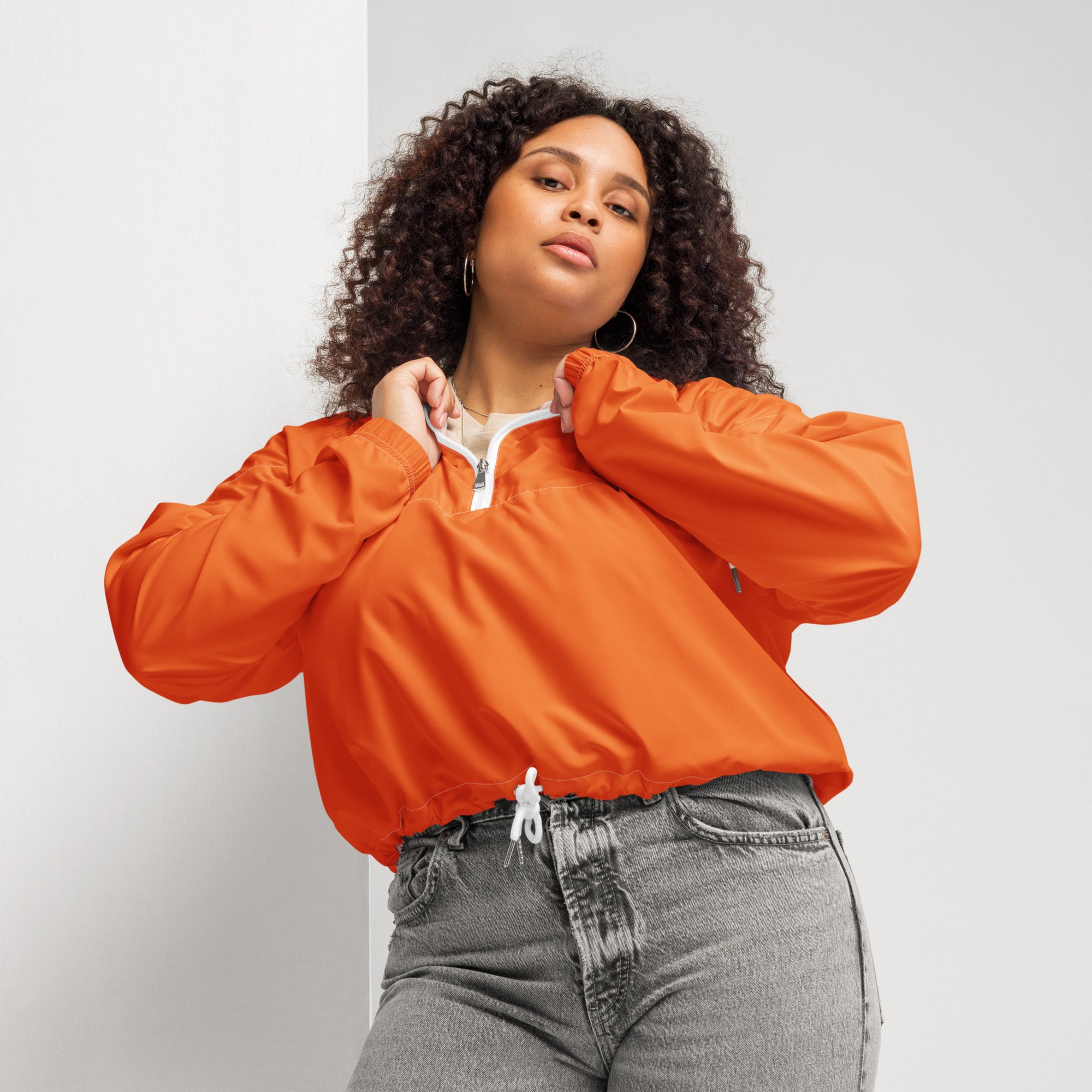 Women’s orange cropped lightweight nylon bomber jacket with white zipper and drawstring hem for wind resistance