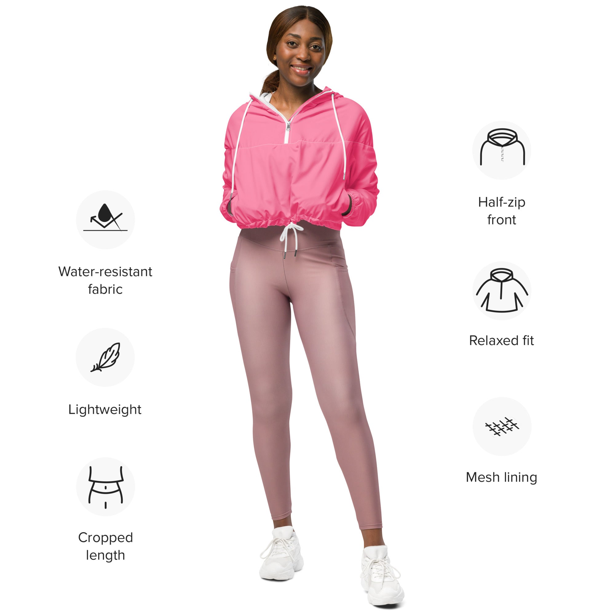 Women’s pink cropped windbreaker with half-zip, white drawstrings, mesh lining, and adjustable hood for lightweight wear