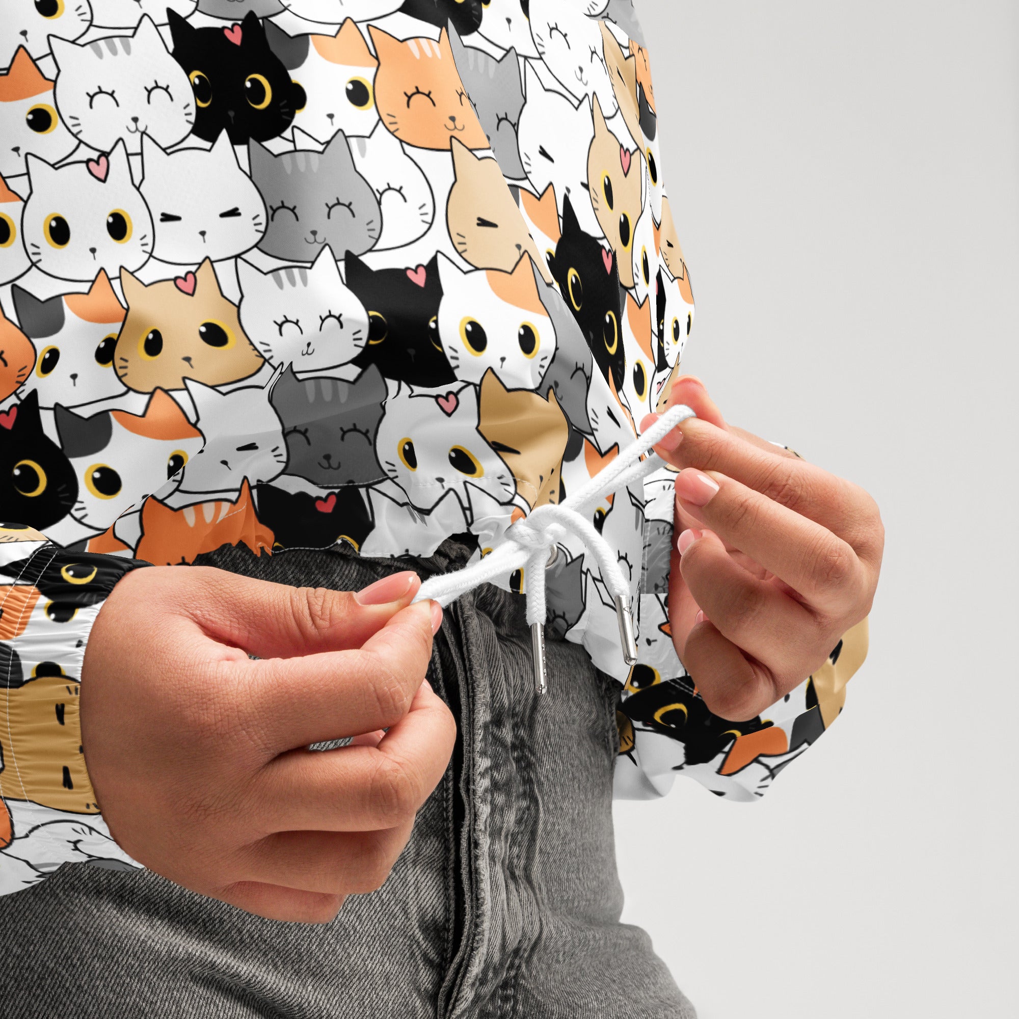 White cropped windbreaker with adjustable hood featuring colorful cartoon cat faces water resistant lightweight jacket