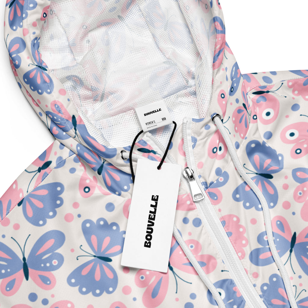 Women’s white cropped rain jacket with pastel pink and blue butterfly pattern made from lightweight water resistant fabric