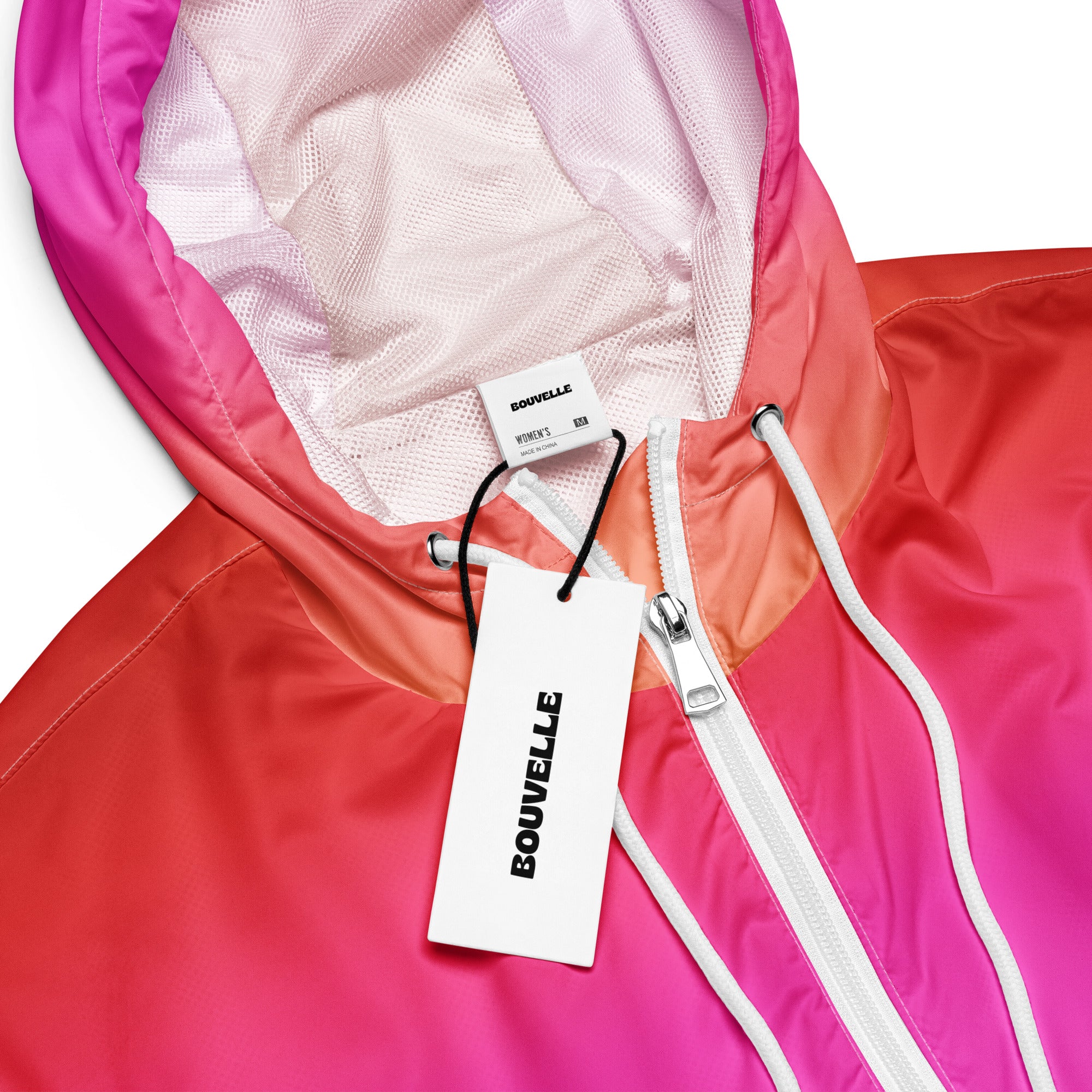 A vibrant gradient pink and orange women’s sunset ombre cropped windbreaker with mesh-lined hood and pockets