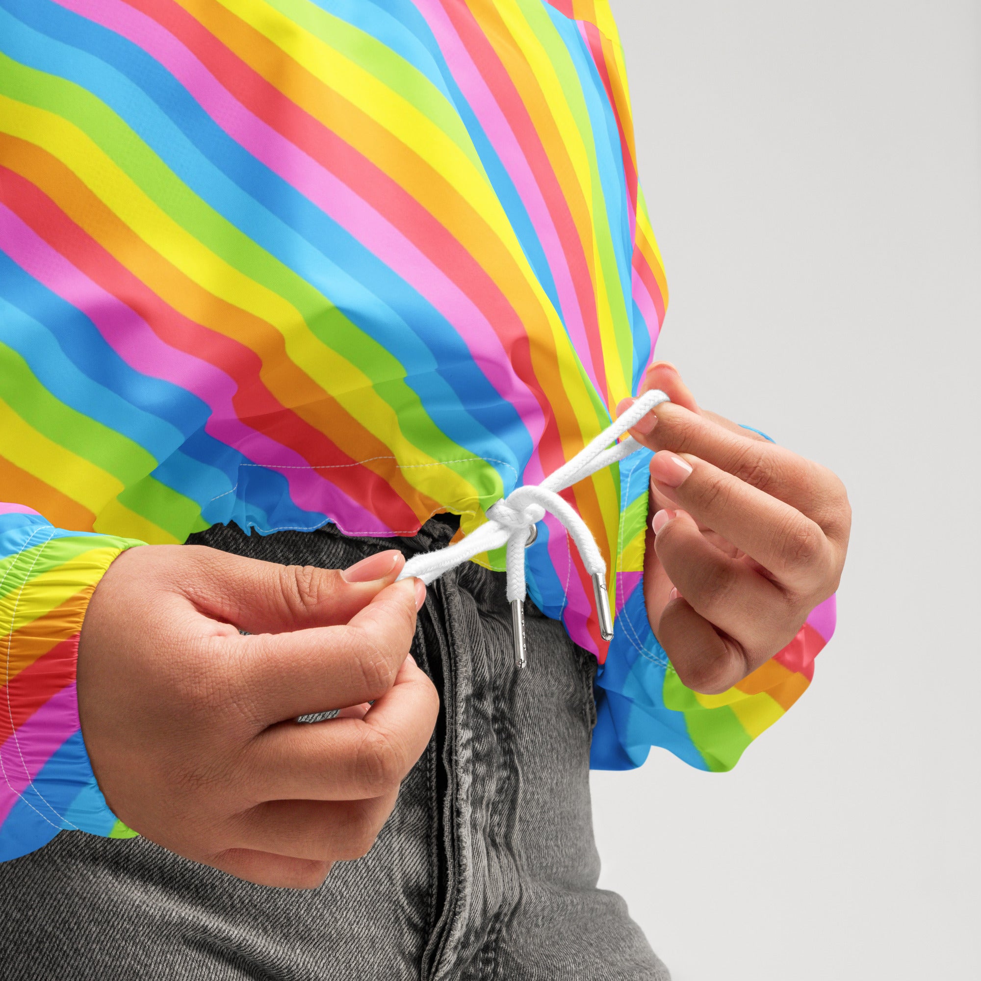 Women’s lightweight water resistant rainbow stripe cropped windbreaker with vibrant diagonal stripes and adjustable hood