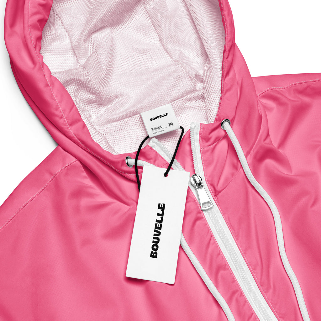 A vibrant pink bouvvelle women’s cropped windbreaker with white zipper mesh lining lightweight and water resistant