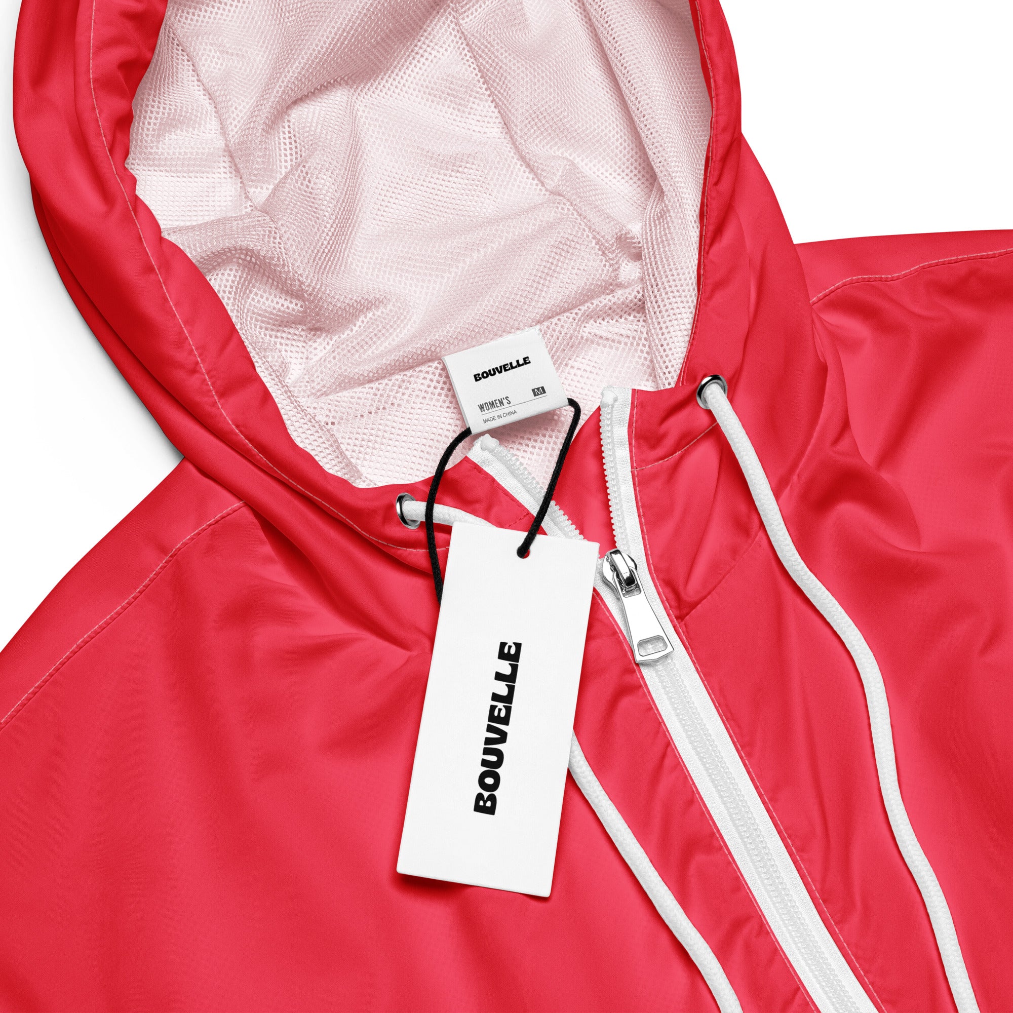 A vibrant red bouvelle women’s hooded jacket with white zipper and mesh lining in a lightweight cropped windbreaker style