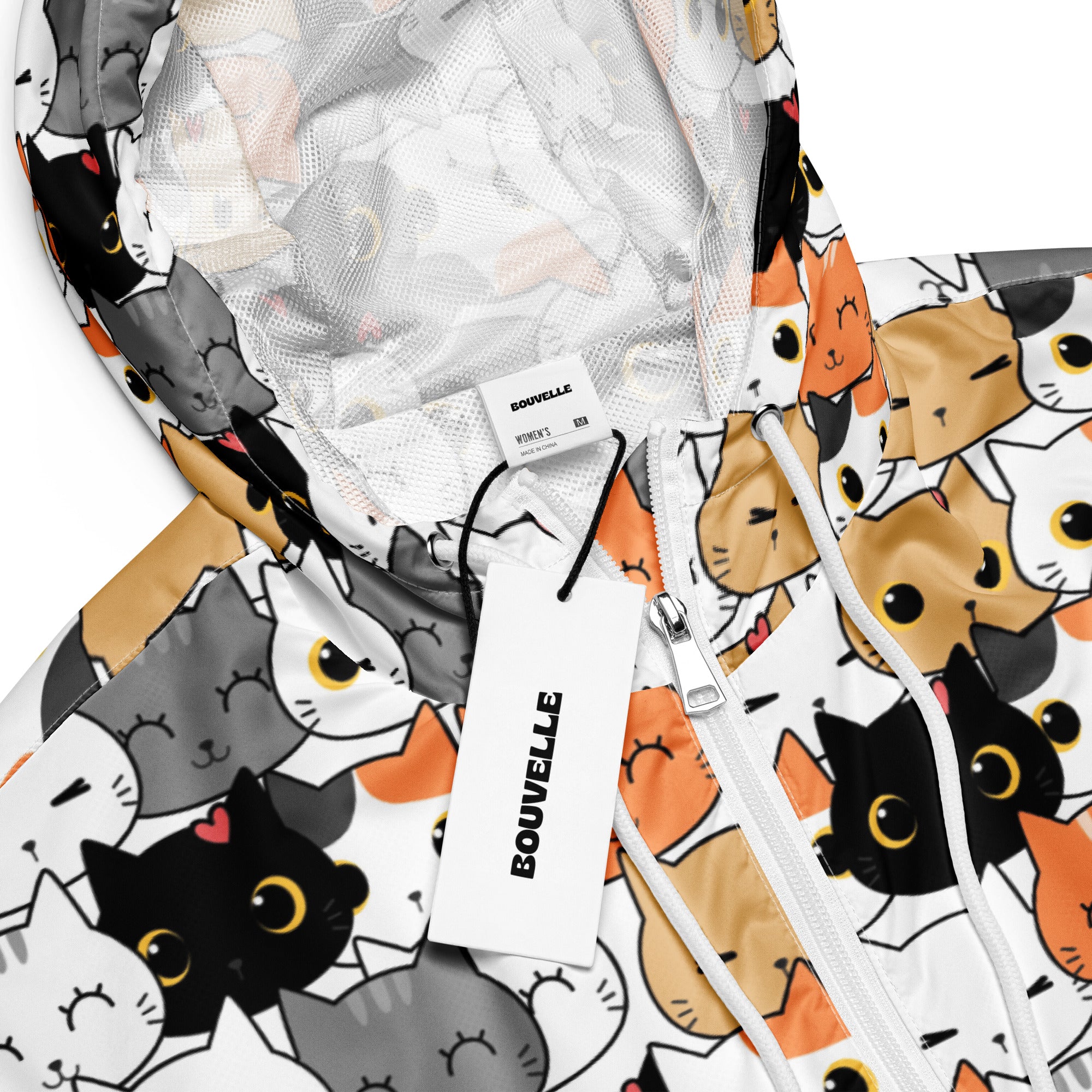 White bouvvelle women’s cropped hooded windbreaker with playful black gray and orange cartoon cat pattern and yellow eyes
