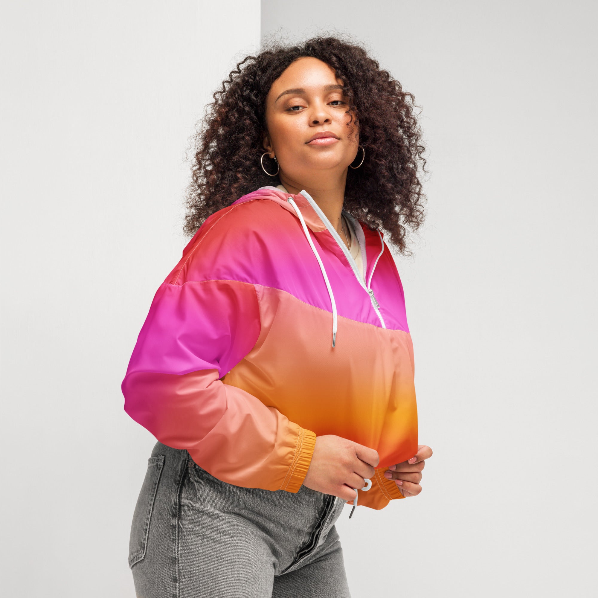 A vibrant pink-to-orange gradient women’s sunset ombre cropped windbreaker with hood and drawstrings