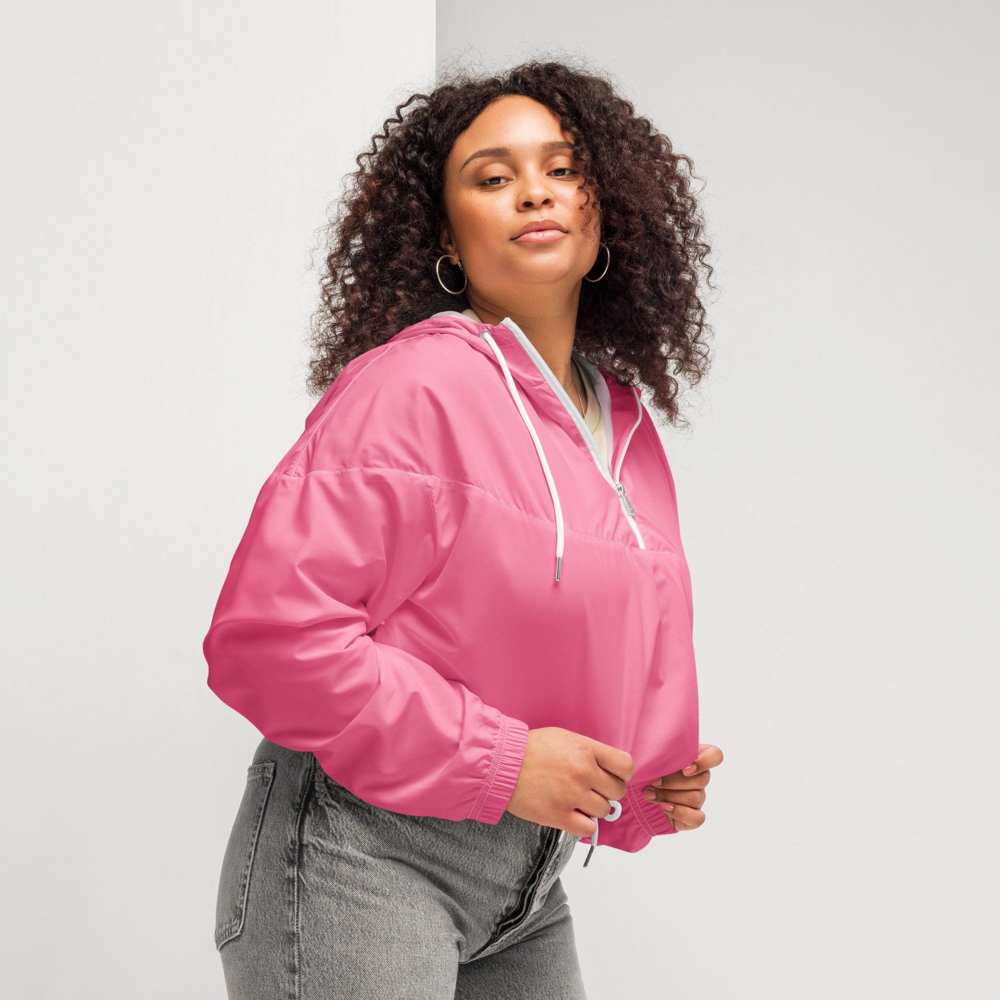 Women’s pink cropped windbreaker lightweight water resistant jacket with adjustable hood white drawstrings and zipper accents