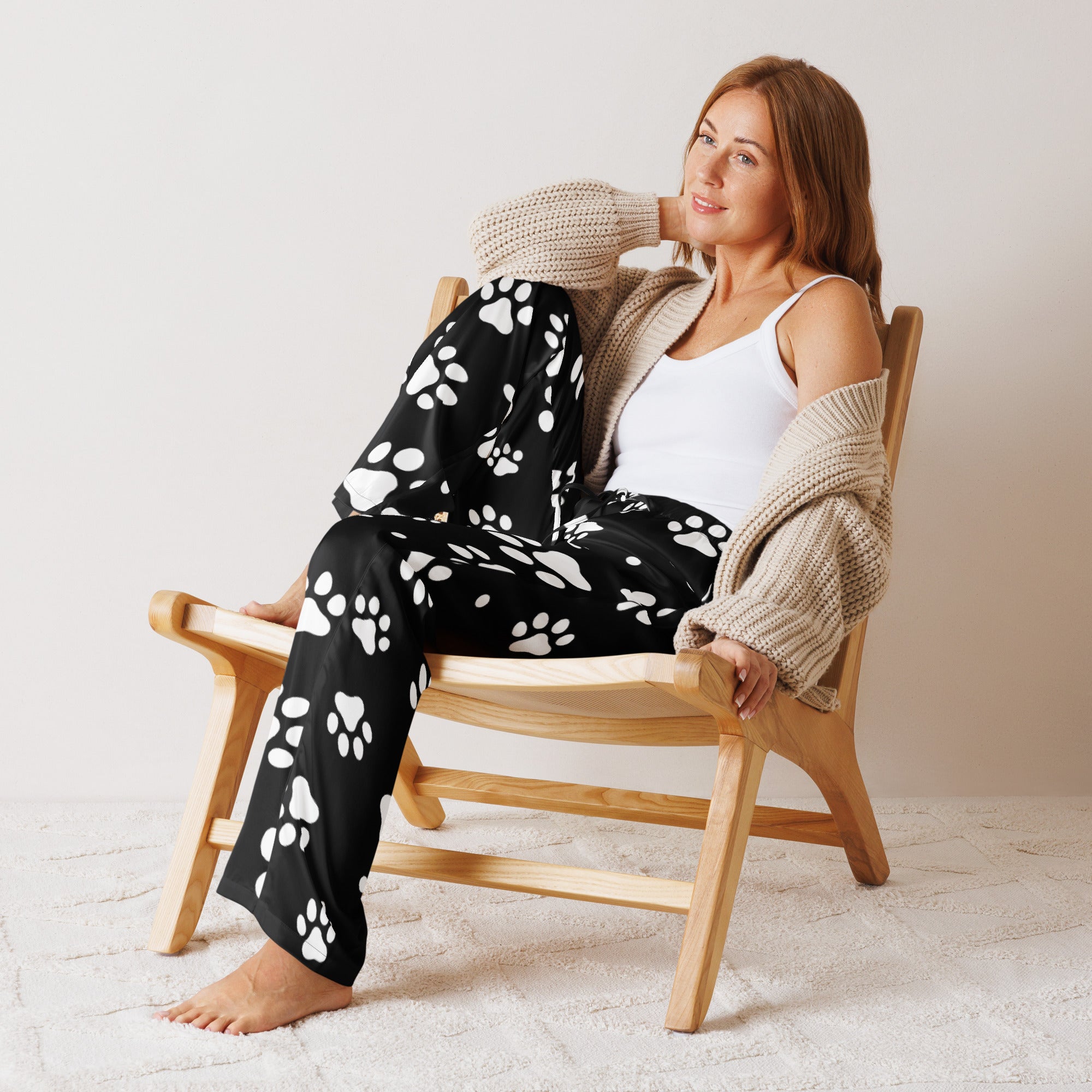 Women’s black lightweight pajama pants with white paw print pattern and relaxed fit featuring a drawstring waist
