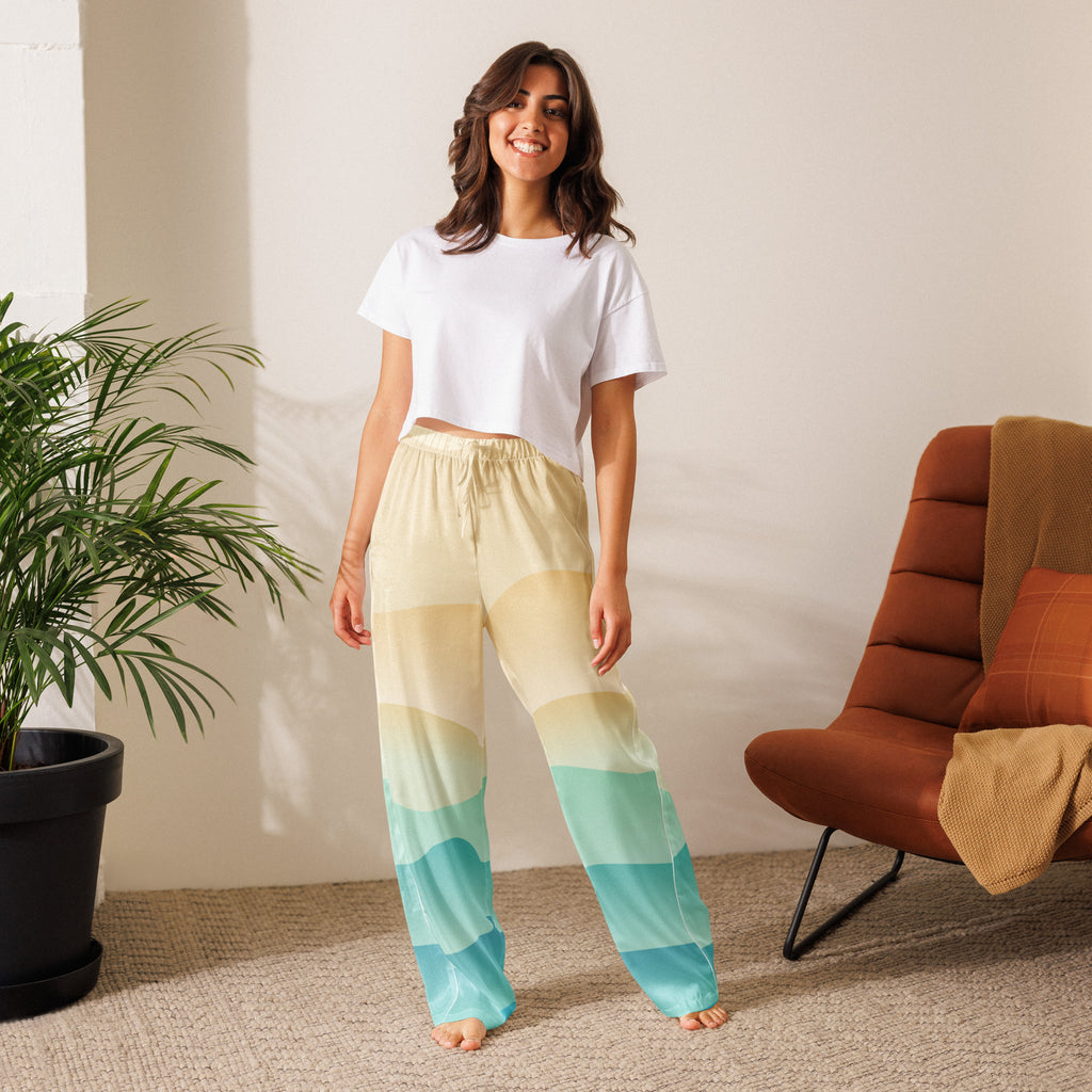 Woman wearing lightweight women’s ocean sunset pajama pants with cream to teal gradient and drawstring waist