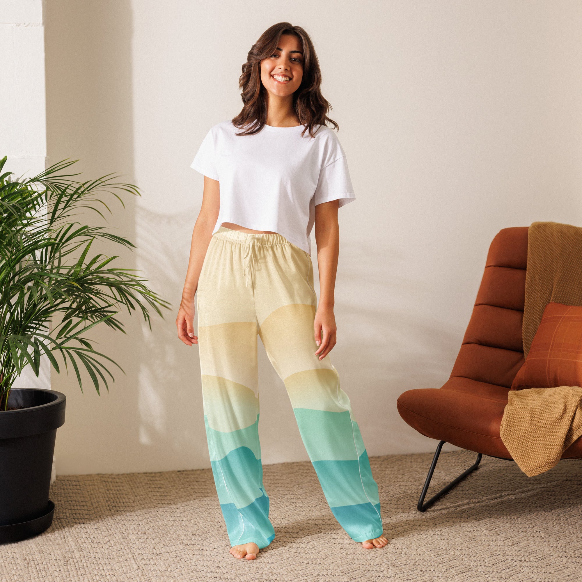 Woman wearing lightweight women’s ocean sunset pajama pants with cream to teal gradient and drawstring waist
