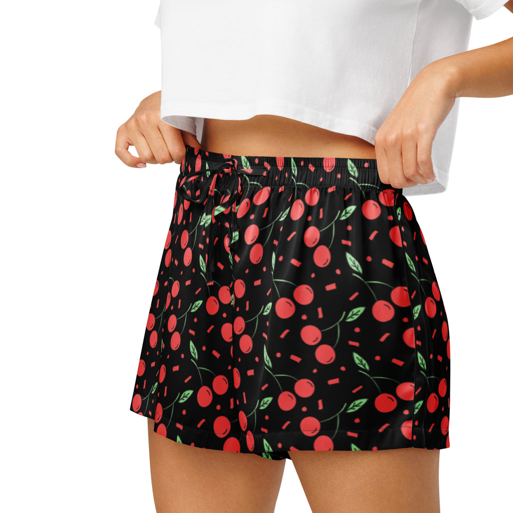 Women’s black silky pajama shorts with vibrant red cherry pattern green leaves and confetti accents lightweight relaxed fit