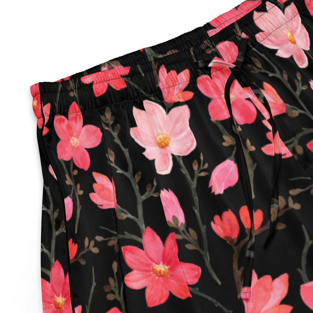 Women’s black silky pajama pants with vibrant pink magnolia flowers and gray branches in a relaxed fit with drawstring waist