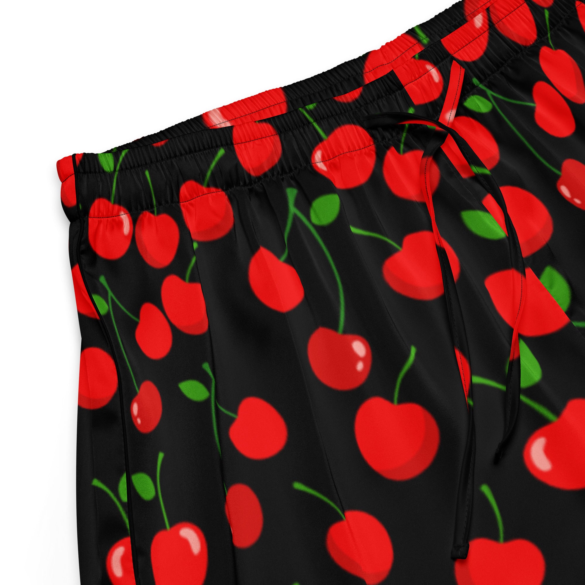 Black pajama pants with red cherry pattern featuring green stems and leaves in lightweight relaxed fit design