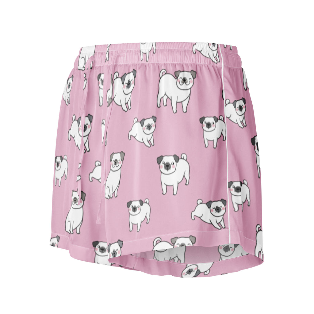 Women’s pink silky pajama shorts with a playful white and gray cartoon pug pattern and a drawstring waist